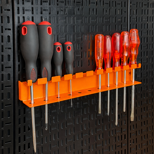 Set of screwdrivers on an orange holder against a black pegboard background