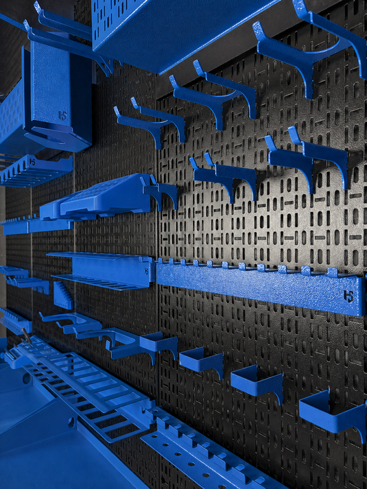Wall-mounted storage system with blue shelves and hooks on a textured black and gray wall.
