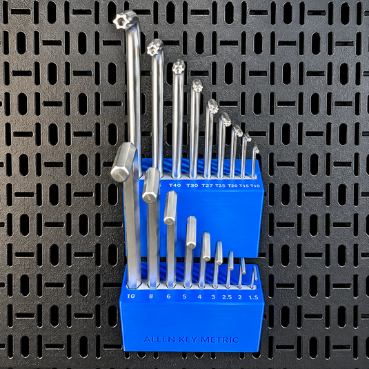 A set of metallic Allen key bits in metric sizes, organized in a bright blue plastic holder with size markings, placed against a black perforated pegboard background.