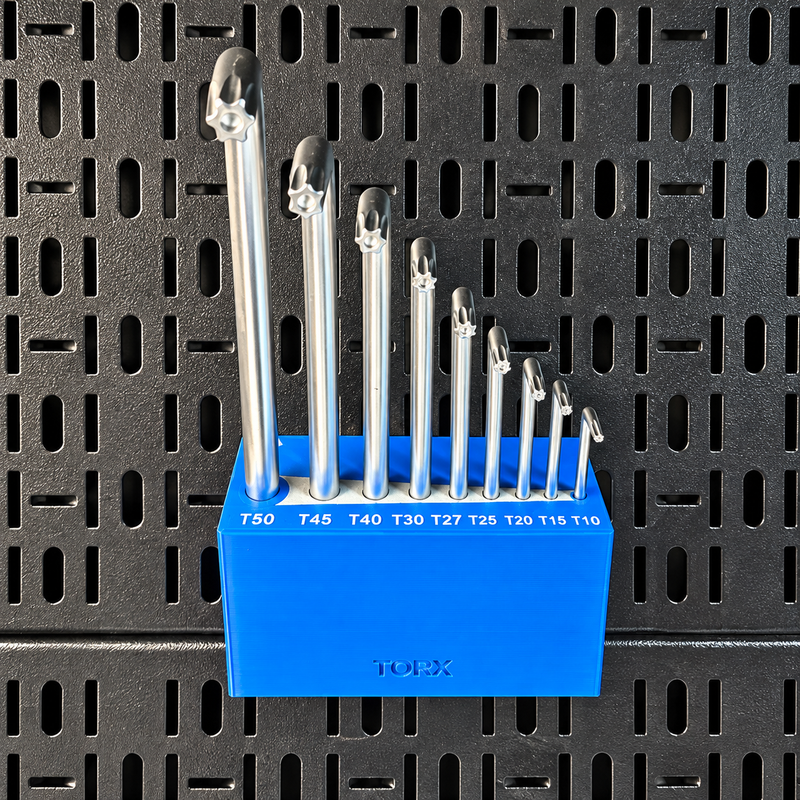 Load image into Gallery viewer, A set of ten metallic T-slotted carbide end mills in various diameters, organized in a bright blue plastic holder with size labels, set against a black metal pegboard background.

