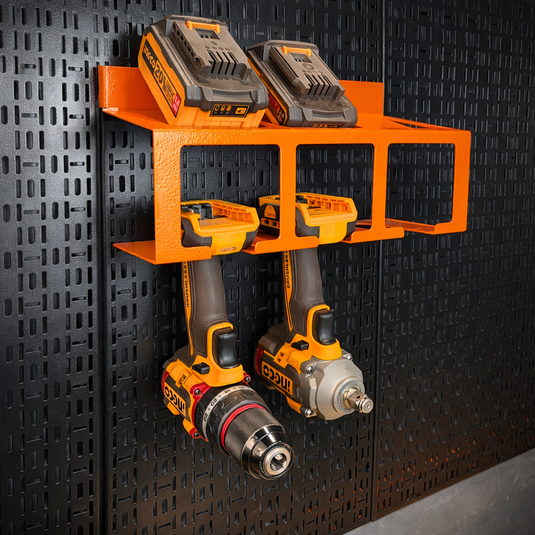 Orange power tool organizer with two drills on a black pegboard wall.