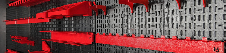 Red storage bins on a black pegboard wall