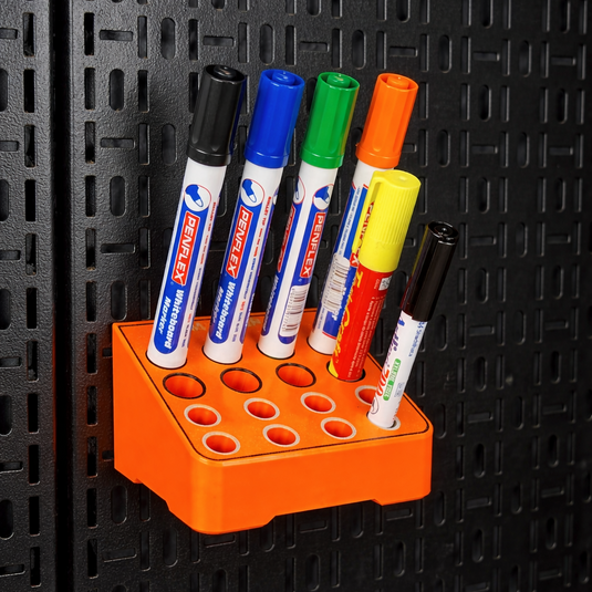Set of markers in a holder against a black textured wall