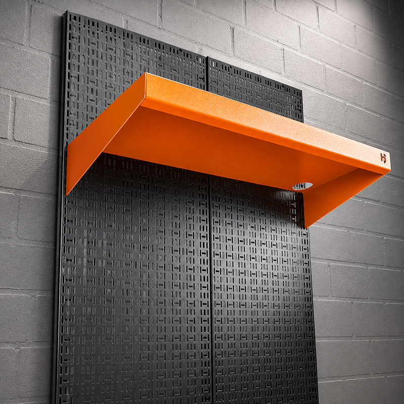Load image into Gallery viewer, Orange shelf mounted on a textured black panel against a gray brick wall.
